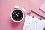 Pink background, analogue clock and calendar